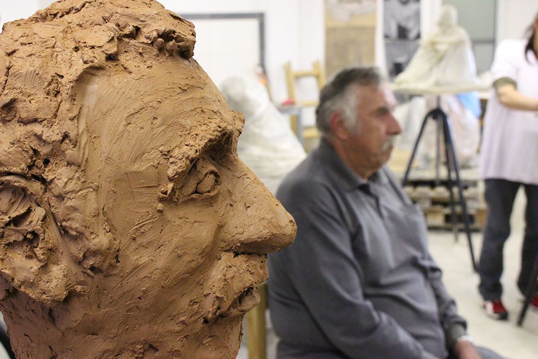 Modeling a portrait in clay.