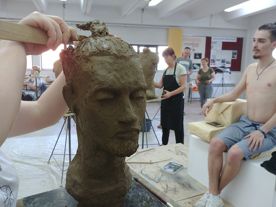 Modeling a portrait in clay.