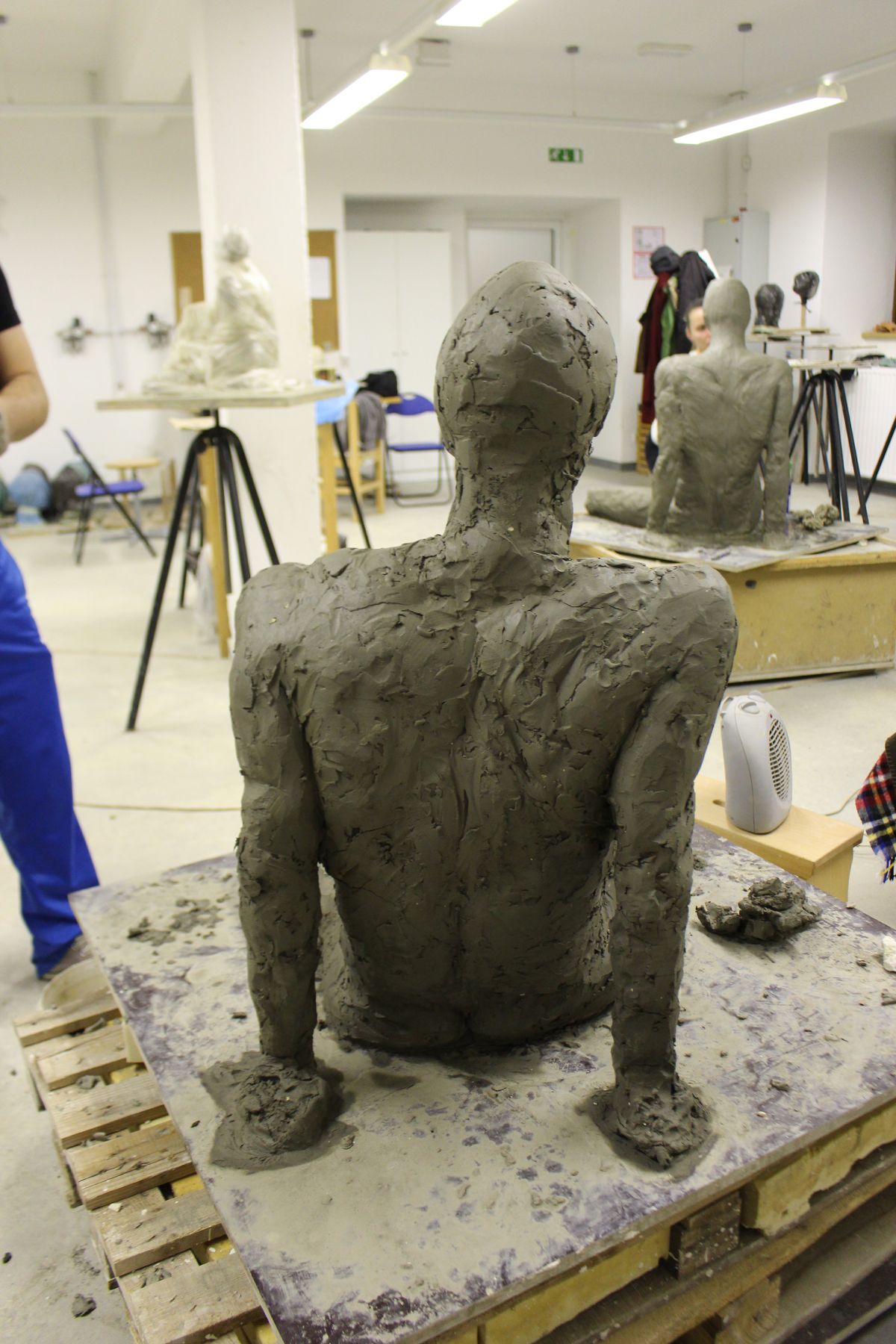 Modeling a real-size seated figure in clay.