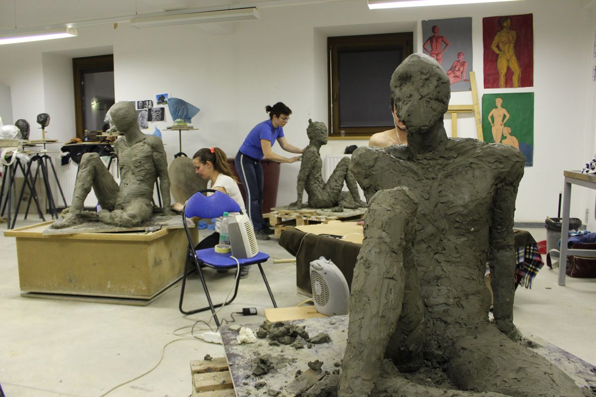 Modeling a real-size seated figure in clay.