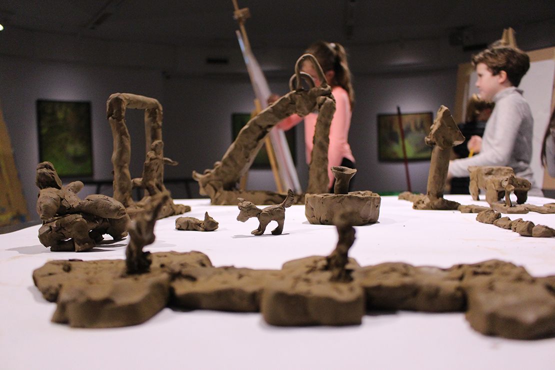 Children modeling playground in clay.