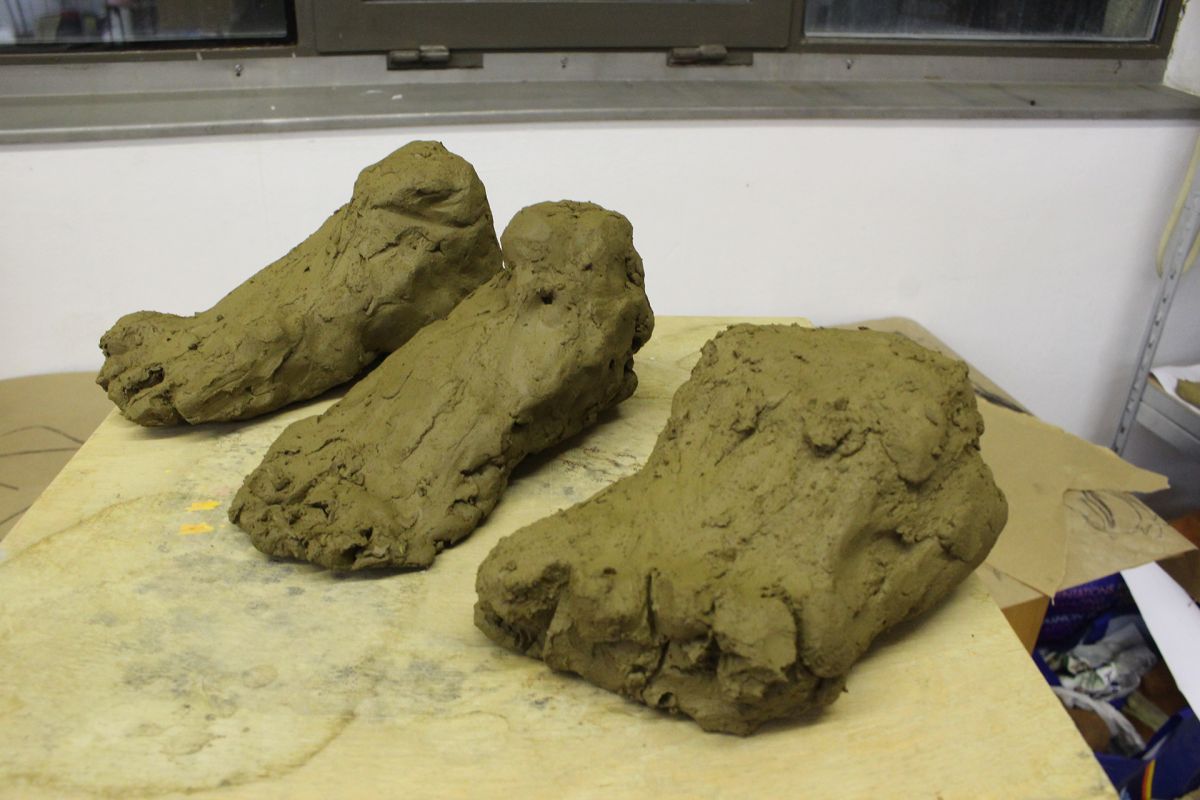 Modeling a foot in clay.