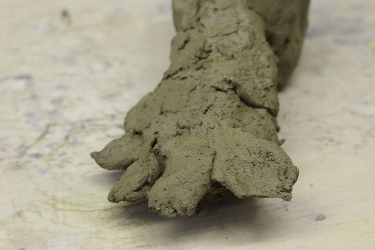 Modeling a foot in clay.