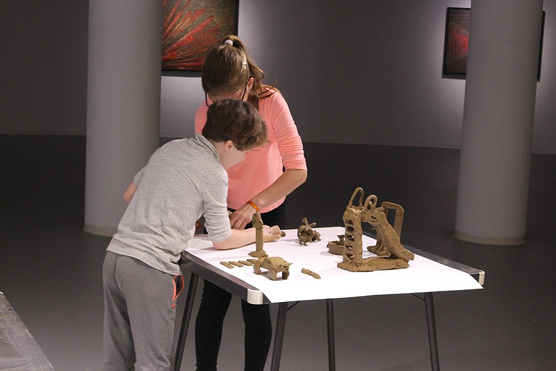 Children modeling playground in clay.