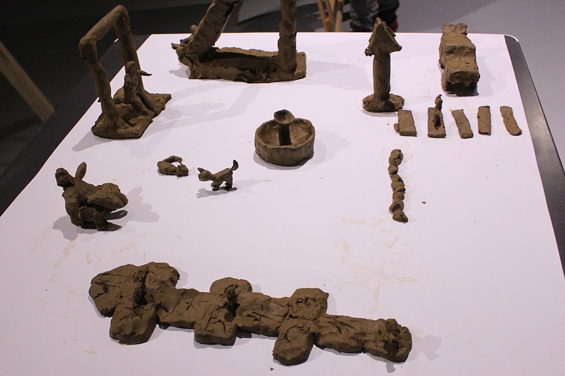 Children modeling playground in clay.