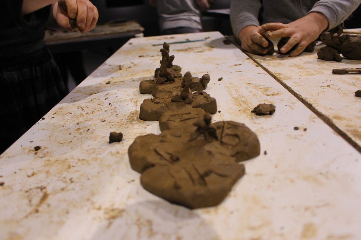 Children modeling playground in clay, close-up.